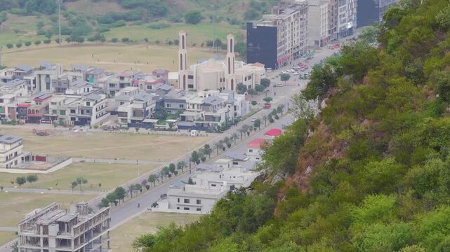 Scenic view of Margalla Hills slope overlooking modern residential houses and cricket ground in Faisal Hills Wah Cantt