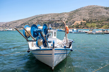 Traditional fishing boat with blue net reels moored at Lithi harbor, Ikaria Island, Greece © Rawf8