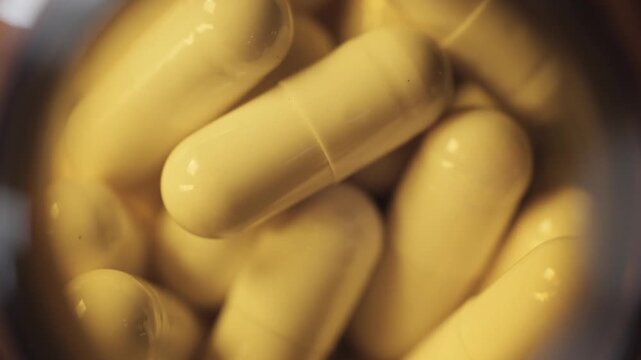 Extreme macro close-up of medicine capsules and pills inside bottle, healthcare and pharmacy concept