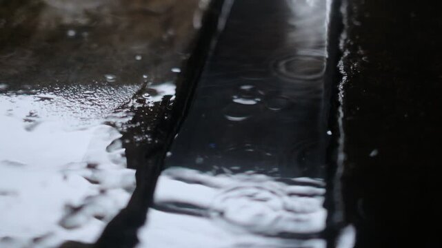 Close-up of rain cascading down metal drainage