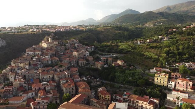 Aerial drone flight over the historic old town of Scalea, Calabria, Italy, showing traditional houses and scenic mountain landscape, 4K.
