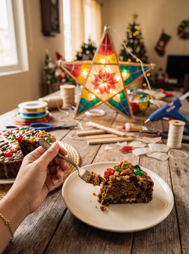 Hand Holding Slice of Filipino Fruitcake Beside Handcrafted Capiz Parol Lantern