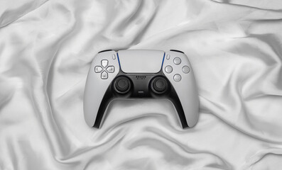 Modern white video game controller on folded silk fabric back © solidmaks