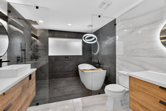 Modern bathroom with glass partition and wood vanity