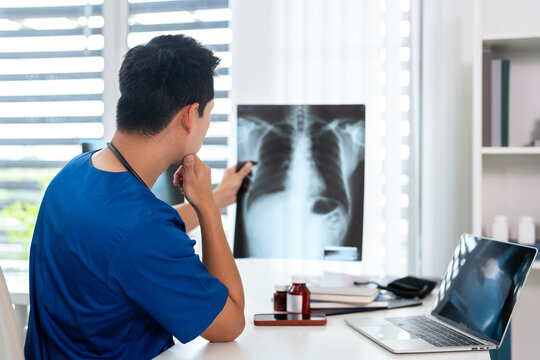 Doctor radiology  holding x-ray film , reviewing patient diagnosis results in clinic.