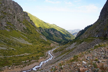 Fototapeta premium Mountain gorge in Almaty, Kazakhstan, with spectacular Tien Shan landscapes, pristine nature and dramatic peaks, popular destination for tourism, hiking, adventure travel and outdoor recreation.