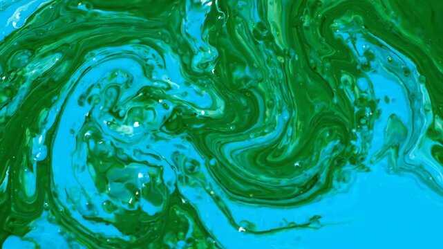 Seamless loop of vibrant emerald green and deep cyan liquid inks swirling slowly and blending together in an amorphous abstract motion background