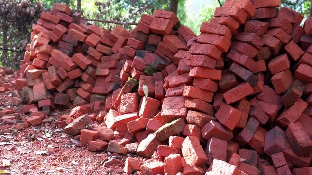 屋外に積み上げられた赤レンガの山、建設資材の風景（Stacked Red Clay Bricks Piled Outdoors）