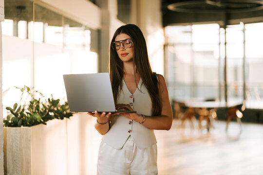 Professional woman working on a laptop in a bright office