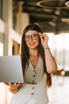 Professional woman working with a laptop in a modern office space during the daylight hours