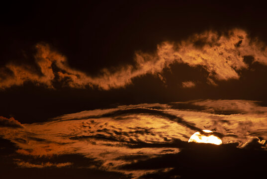 Spooky full moon rising through desert clouds at night
