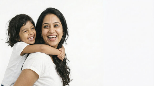 Happy Indian mother giving piggyback ride to her young daughter on white background