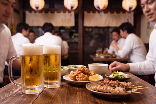 賑わう日本の居酒屋で楽しむ生ビールと料理・仕事帰りの飲み会