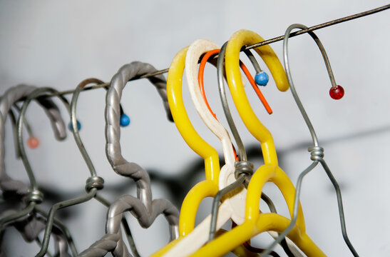 Close up a bunch of dirty coat hanger hanging on indoor rustic wire