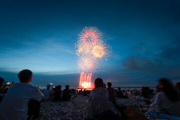 Obraz premium Colorful fireworks finale above a beach crowd in Osaka Japan