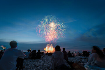 Obraz premium Multicolor fireworks and launch fans over Osaka beach crowd