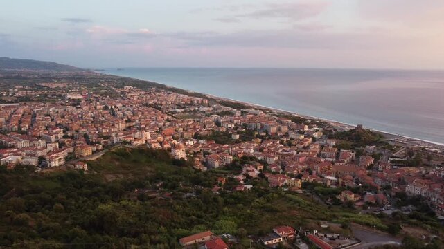 Aerial panoramic view of Scalea town and Mediterranean coastline at dusk, featuring a beautiful pastel evening sky, Calabria, Italy, 1080p.
