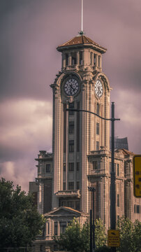 View of the historic Shanghai Customs House clock tower with its neoclassical facade and spire under a cloudy sky in Shanghai, Shanghai, China.