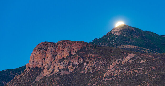 Moments before the moon sets and sun rises in Arizona on the Huachuca Mountains.