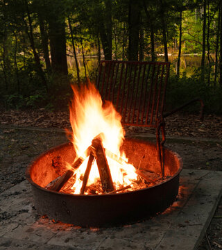 Dark campsite next to a lake with campfire burning