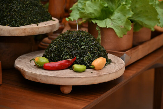 finely chopped couve collard greens, red pimenta dedo de mo&ccedil;a peppers, green lettuce, and rustic decorations on feijoada buffet table, catering display horizontal shot