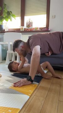 Father exercising with toddler on floor