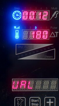 close-up portrait of commercial oven control panel with red seven-segment displays cycling between timer and temperature values and alphanumeric status messages