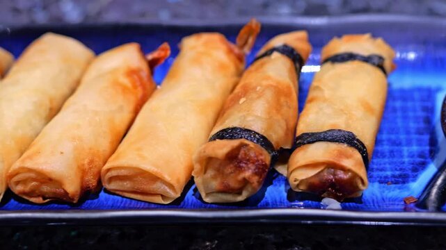 Close-up of assorted golden fried spring rolls with shrimp and vegetable fillings, arranged together as a crispy Asian-style appetizer with varied textures.
