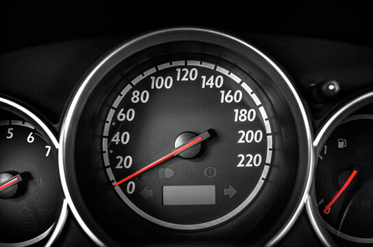 Car speedometer displaying the dashboard instrumentation panel with a red indicator needle.
