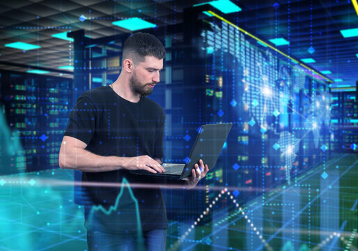 Data analytics monitoring platform engineer analyzing digital network performance using laptop in high-tech server environment