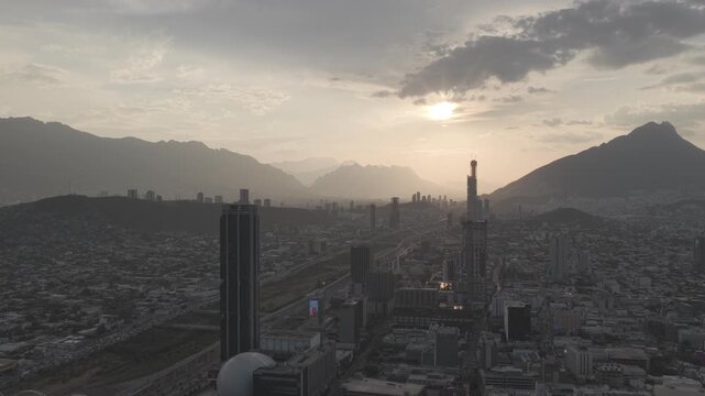 Aerial panoramic view of the downtown Monterrey skyline during golden hour at sunset with mountains and dramatic backlight, Nuevo Le&oacute;n. D-Log M