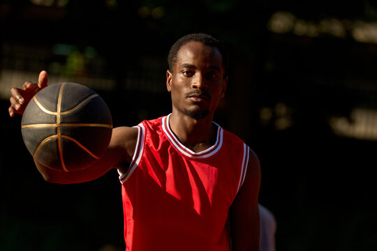Player Prepares for Basketball Game at Outdoor Court in Sunlight