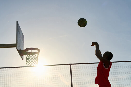 Young Player Shooting a Basketball Towards the Hoop