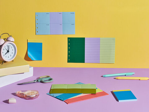 Colorful stationery and desk accessories arranged on a purple surface