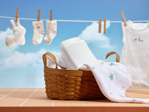 Laundry basket with detergent and baby clothes drying on a clothesline