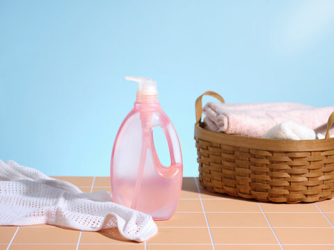Pink laundry detergent bottle and basket of clean towels