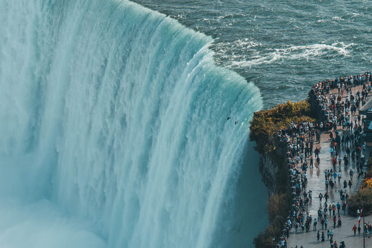 Niagara Falls waterfall cascading over rocky cliff edge with powerful flowing water motion