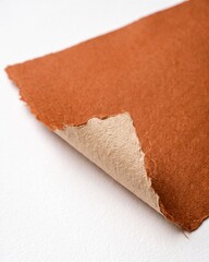 Obraz premium Close-up View of Terracotta Colored Handmade Paper Sheet with Rough Deckle Edges and Visible Texture