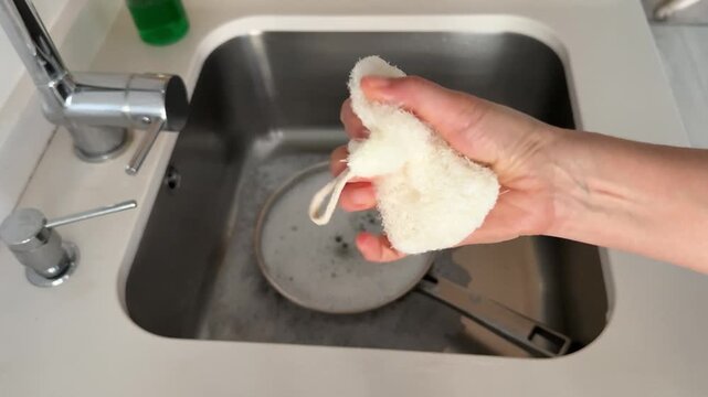 Cleaning a Stainless Steel Pan with an Eco-Friendly Loofah Sponge
