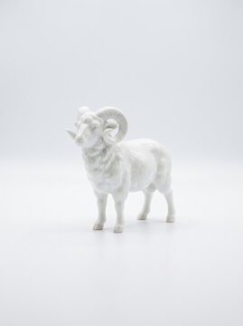 白背景に立つ雄羊の白い陶器製フィギュアと置物素材