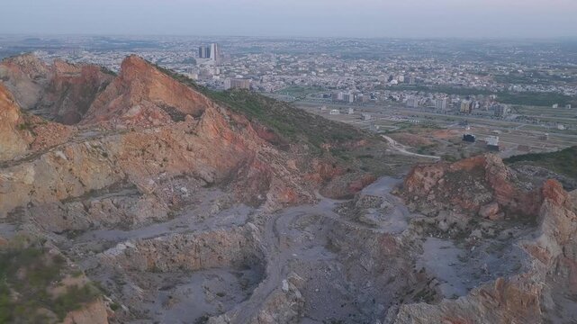 Aerial view of rocky mountain stone quarry overlooking B-17 Multi Gardens and J7 Emporium Islamabad
