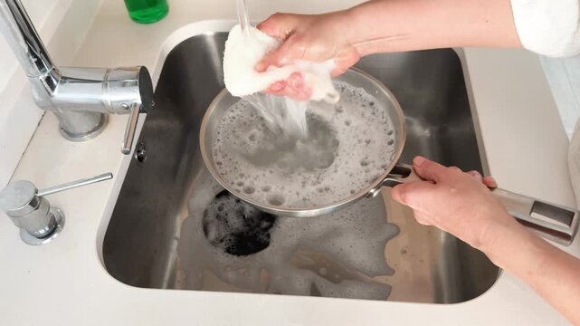 Cleaning a Stainless Steel Pan with an Eco-Friendly Loofah Sponge