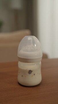 Baby Formula Milk Bottle Standing on a Table in a Warm Home Interior