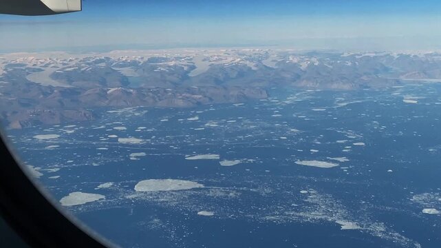 Aerial view of arctic land in northern Greenland. A view out the window from the Helsinki to Seattle arctic polar route towards the Sverdrup Island area at 83 degrees northern latitude.