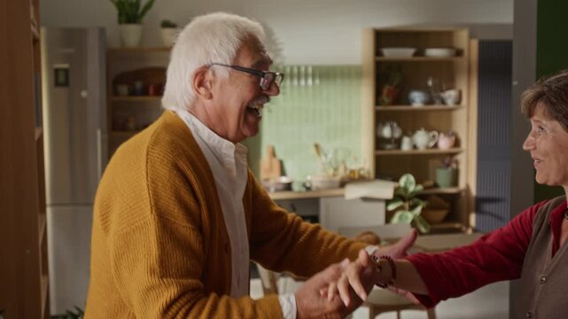 Senior Caucasian man turning on radio and dancing with smiling Caucasian senior woman at home. Clip suitable for active aging campaigns, retirement marketing, and senior relationship content