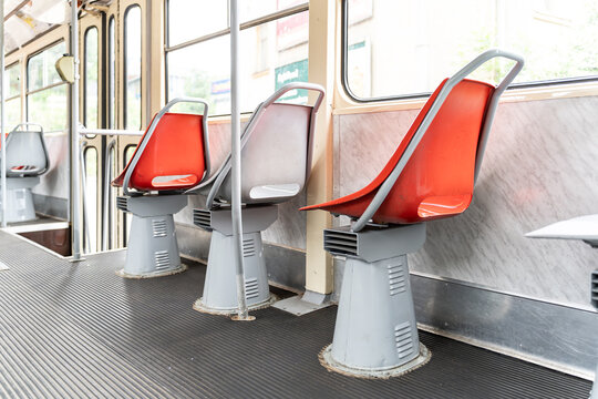 Interior of a vintage Tatra T3 tram with iconic red and grey plastic seats. Retro public transport in Prague, Czech Republic.