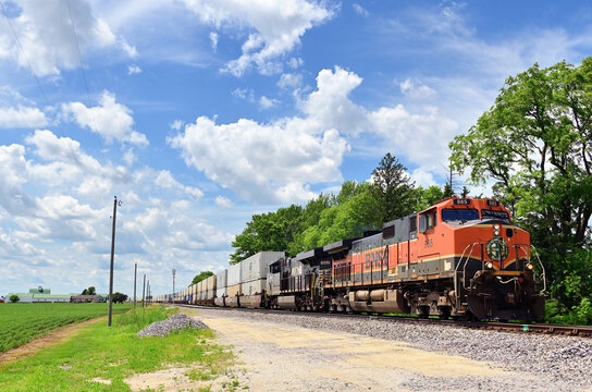 Two locomotives lead a Burlington Northern Santa Fe intermodal freight train as it moves eastbound along the mainline toward Chicago.