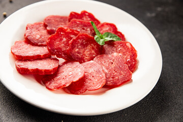 Obraz premium Sliced sausage meat dried sausage beef halal tasty appetizer, dish table setting, culinary background rustic style dish, top view copy space
