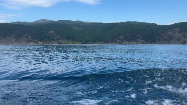 Cruising on a ferry boat over deep blue lake water