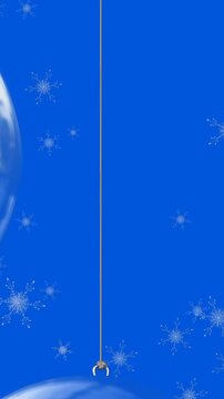 Animation of snow falling over christmas bauble decorations on blue background